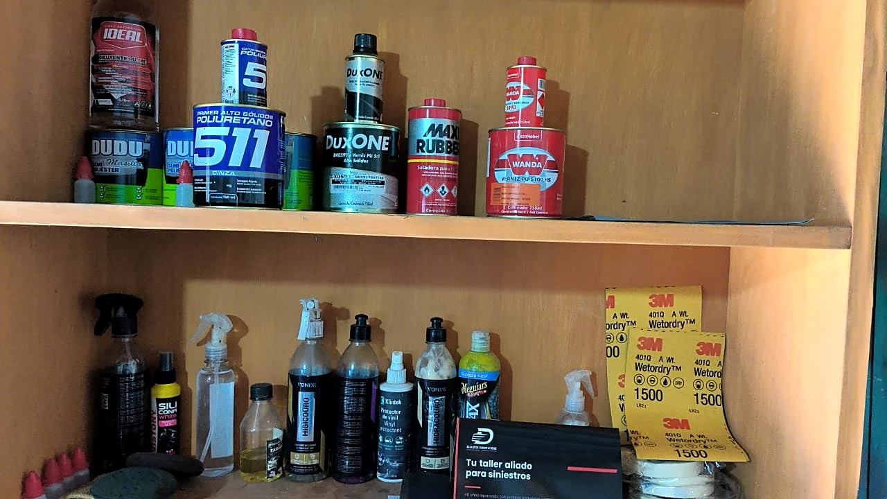 Estante con productos de pintura en el taller